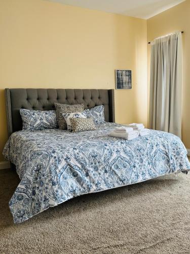 a bedroom with a bed with a blue and white bedspread at Entire Modern Home near Stadiums, Hospitals, and Schools in Baltimore