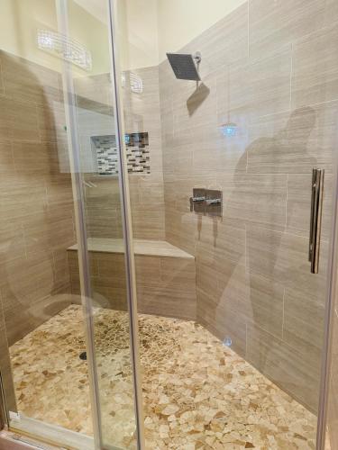 a shower with a glass door in a bathroom at Entire Modern Home near Stadiums, Hospitals, and Schools in Baltimore