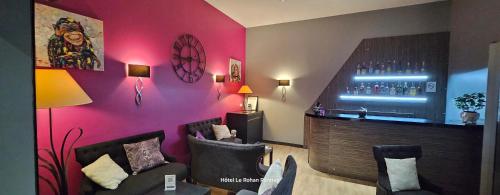 a room with a bar with two chairs and a couch at Hôtel Le Rohan Charme et Caractère in Pontivy