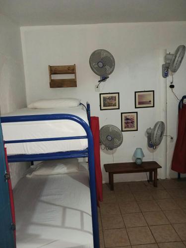 a room with a bunk bed and two fans at Hostel SaltWater in San Juan del Sur