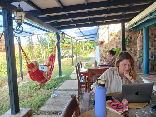 a woman sitting at a table with a laptop at Hostel SaltWater in San Juan del Sur
