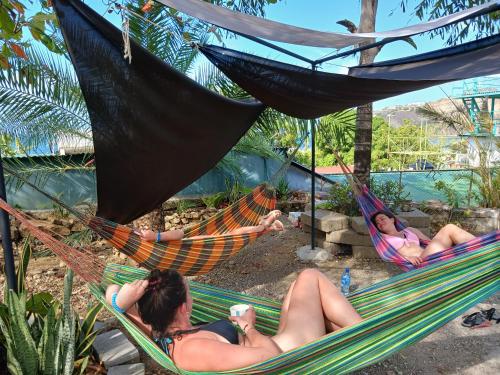two women laying in hammocks on a beach at Hostel SaltWater in San Juan del Sur