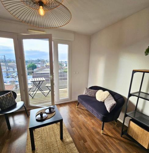 un salon avec un canapé et une table dans l'établissement [Cosy] Appartement équipé avec terrasse, Wifi, à Pont-de-la-Maye