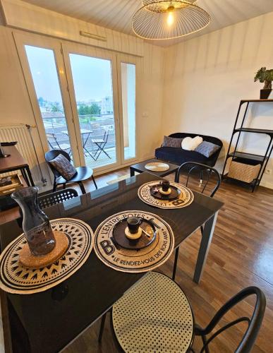 uma sala de estar com mesa e cadeiras em [Cosy] Appartement équipé avec terrasse, Wifi em Pont-de-la-Maye