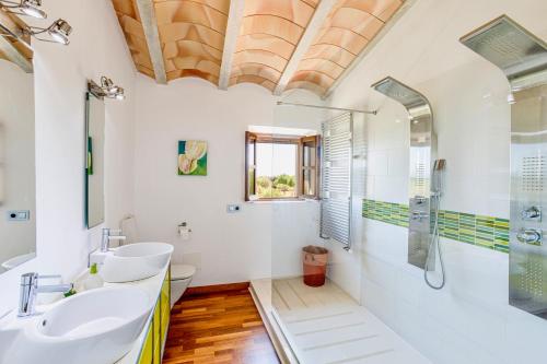 ein Bad mit 2 Waschbecken und einer Dusche in der Unterkunft Cas Coix. Jacuzzi, gimnasio y piscina in Biniali