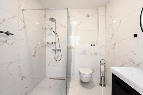 uma casa de banho branca com um chuveiro e um WC. em Villa Nada em Drače