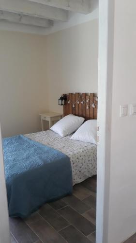 une chambre avec un lit avec une tête de lit en bois dans l'établissement Mas de l espine, à Eygalières