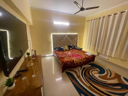 a bedroom with a bed and a flat screen tv at Silicon Valley in Lucknow