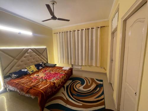 een slaapkamer met een bed en een plafondventilator bij Silicon Valley in Lucknow