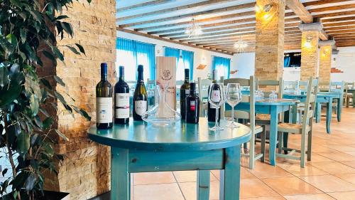 a table with wine bottles and glasses on it at La Perla Hotel in SantʼAnna Arresi