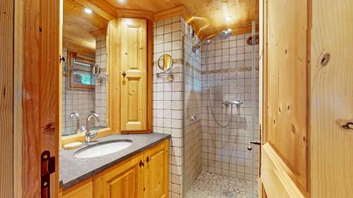 un baño con lavabo y ducha en Chalet La Grande Ourse Meribel - 165m2 apartment almost ski-in ski-out, en Méribel