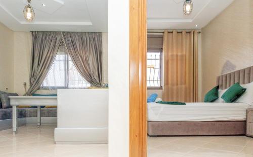 a bedroom with a bed and a desk in front of a window at Imsouane Wave Residences in Imsouane