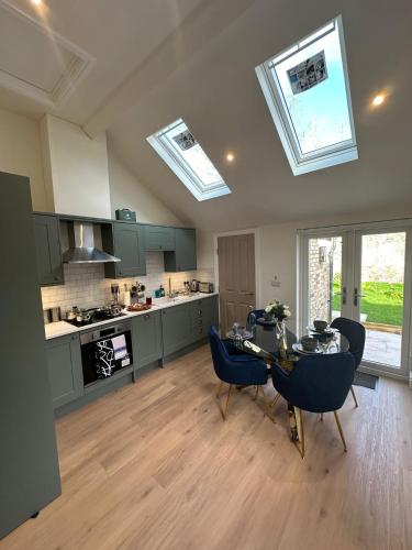 a kitchen with a table and chairs and skylights at Central Cambridge Apartments by Tas in Cambridge