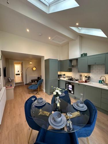 a living room with a table and chairs and a kitchen at Central Cambridge Apartments by Tas in Cambridge