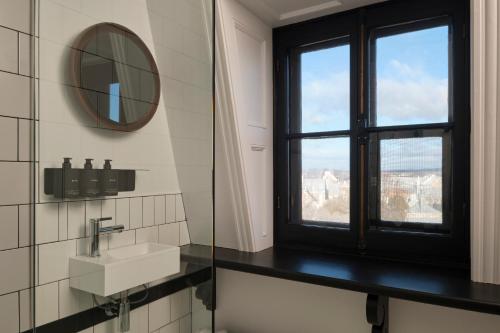 a bathroom with a window and a sink and a mirror at Hotel Cap Diamant in Quebec City