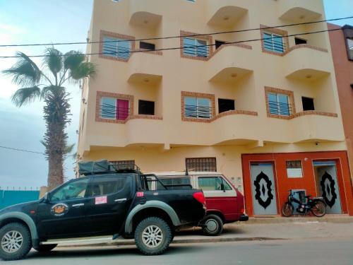 a black truck parked in front of a building at Titanic by ahmed in Mirleft