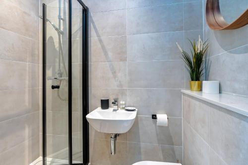 a bathroom with a toilet and a sink and a shower at Balloon Suite: Modern Luxury in Bristol