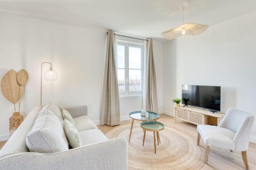a living room with a couch and a tv at Appartement Bécasseau - La Maison Heureuse - Welkeys in Saint-Georges-dʼOléron