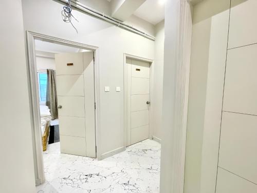 a bathroom with white walls and marble flooring at Stay Inn Kaashvi (A unit of Admire India Tourism Pvt. Ltd.) in Varanasi