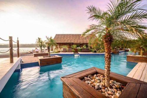 una piscina con una palmera y un complejo en LUXURY Apartment in BLUE Playa Venao D-32 en Playa Venao
