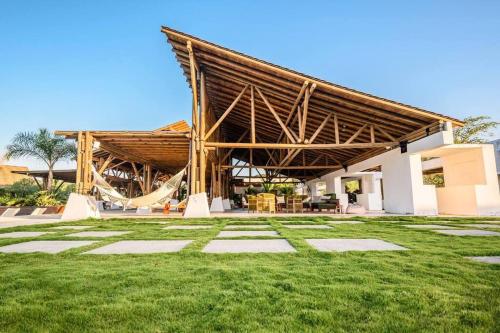 a large building with a hammock in a yard at LUXURY Apartment in BLUE Playa Venao D-32 in Playa Venao