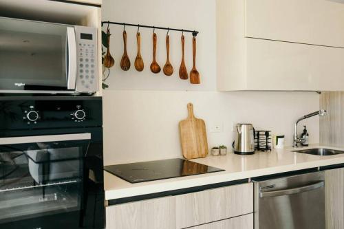 a kitchen with a microwave oven and a stove at LUXURY Apartment in BLUE Playa Venao D-32 in Playa Venao