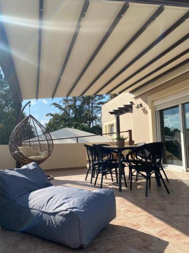 a patio with a table and chairs and a couch at Villa KIMA Heated Pool in Episkopi (Heraklion)