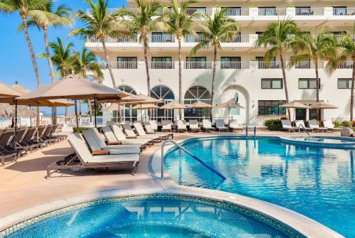 a pool at a hotel with chairs and umbrellas at Villa del Palmar Beach Resort & Spa Puerto Vallarta in Puerto Vallarta