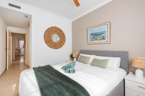 a bedroom with a large white bed and a mirror at Casita Caracol - peace and quiet in Denia