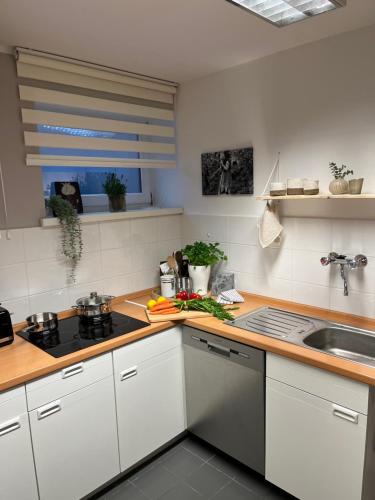 a kitchen with white cabinets and a sink at Privatwohnung mit Terrasse zum Relaxen in Lennestadt