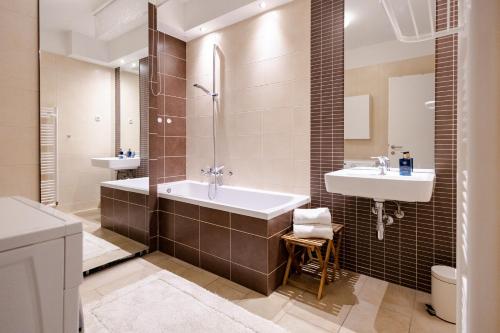 une salle de bain avec une baignoire et un lavabo dans l'établissement Waterfall Apartment - Cozy Mountain Retreat, à Kranjska Gora