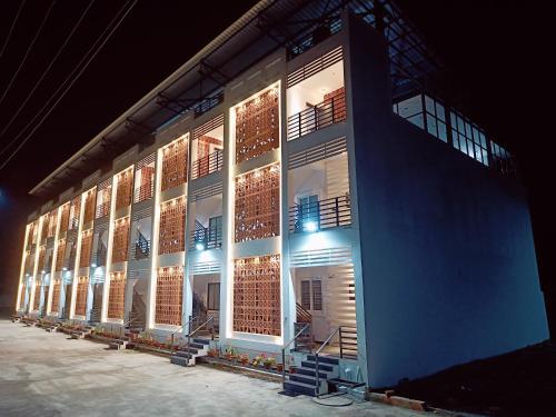 a large building with lit up windows at night at Devaki Resort in Pondicherry