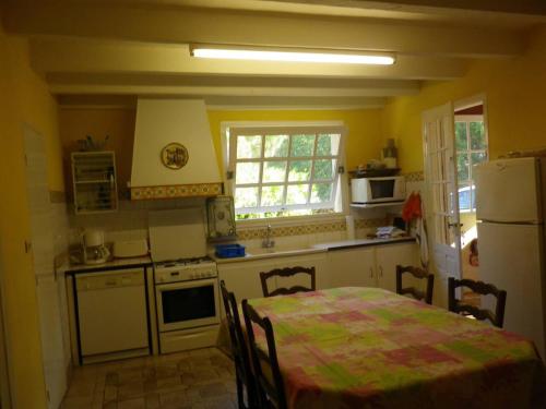 Il comprend une cuisine équipée d'une table et d'un réfrigérateur. dans l'établissement Maison chaleureuse à Vielle-Saint-Girons, à Vielle-Saint-Girons