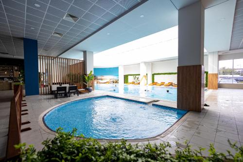 a large swimming pool in a hotel lobby at 19th Floor Secure Condo with Pool, Fitness, Parking Included in Price in Skopje
