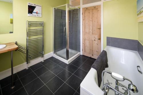 uma casa de banho com uma banheira, um chuveiro e um lavatório. em Hotspur House, perfectly located with sea views em Cowes