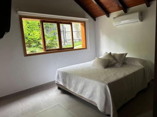 a bedroom with a bed and a window at Casa Chalet en Lagos del Cacique in Bucaramanga