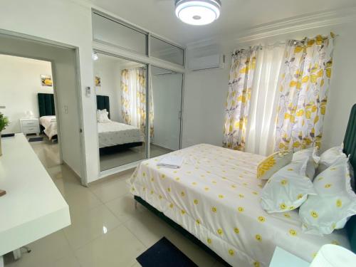 ein Schlafzimmer mit einem Bett und einem großen Spiegel in der Unterkunft Ama4 Residencial AMA in Ensanche Savica de Mendoza
