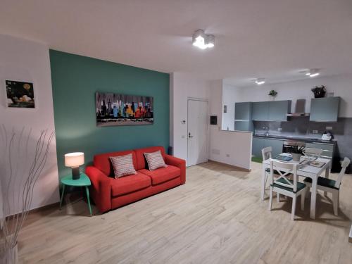 uma sala de estar com um sofá vermelho e uma cozinha em Colour House em Roma