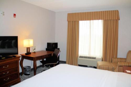 a hotel room with a bed and a desk and a television at Country Inn & Suites by Radisson, BWI Airport Baltimore , MD in Linthicum Heights