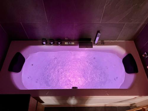 a purple bath tub in a purple bathroom at Villa luxe vue mer panoramique - sauna-hamam - jacuzzi in Marseille