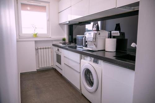 a kitchen with a washing machine and a microwave at Nicolae Balcescu Dream House in Bucharest
