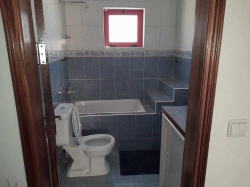 a bathroom with a toilet and a bath tub at Vivenda Na Baia das Gatas in Baia das Gatas