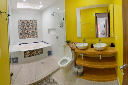 a bathroom with two sinks and a toilet at Hotel Casa David in Rivera