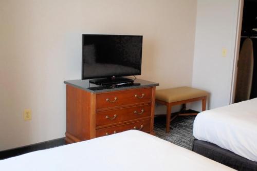a bedroom with a tv on a dresser with a bed at Country Inn & Suites by Radisson, BWI Airport Baltimore , MD in Linthicum Heights