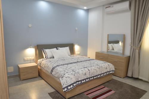 una camera con un grande letto e uno specchio di Complexe Immobilier le Silence (CIS) a Lomé