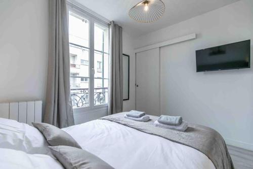 une chambre avec un lit avec deux serviettes dessus dans l'établissement Cosy apartment Alfortville, à Alfortville
