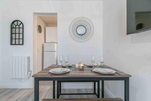 - une table à manger avec des verres à vin et un miroir dans l'établissement Cosy apartment Alfortville, à Alfortville