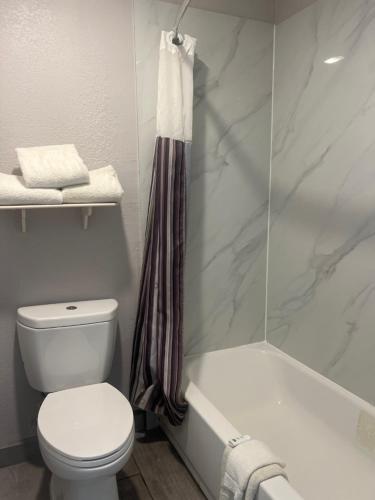 a bathroom with a toilet and a bath tub at La Quinta Inn by Wyndham San Antonio Vance Jackson in San Antonio