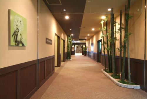 a hallway in a building with plants on the walls at Route Inn Grantia Fukuoka Miyawaka - Wakita Onsen in Miyawaka