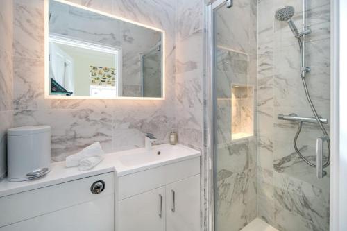 uma casa de banho com um chuveiro, um lavatório e um espelho. em Fifty Two em Cowes